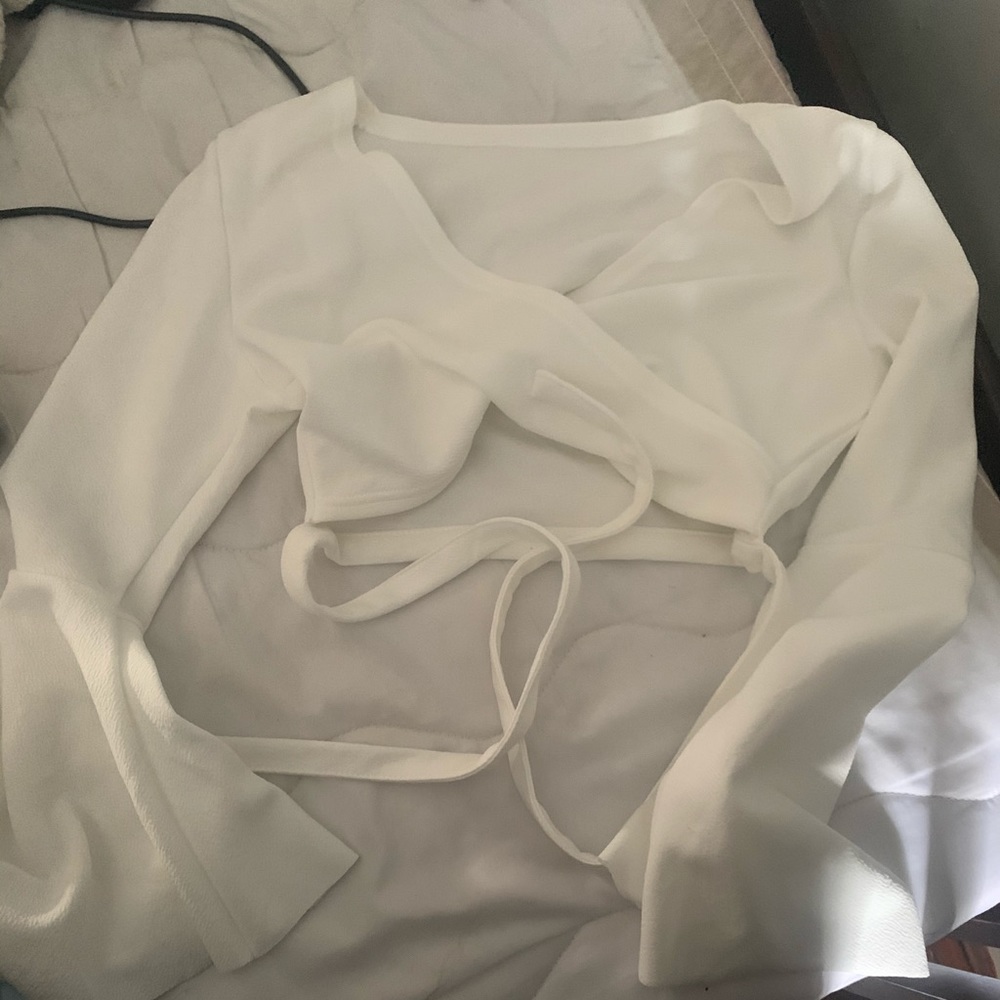 It’s a white cropped. Flowy armed long sleeve top